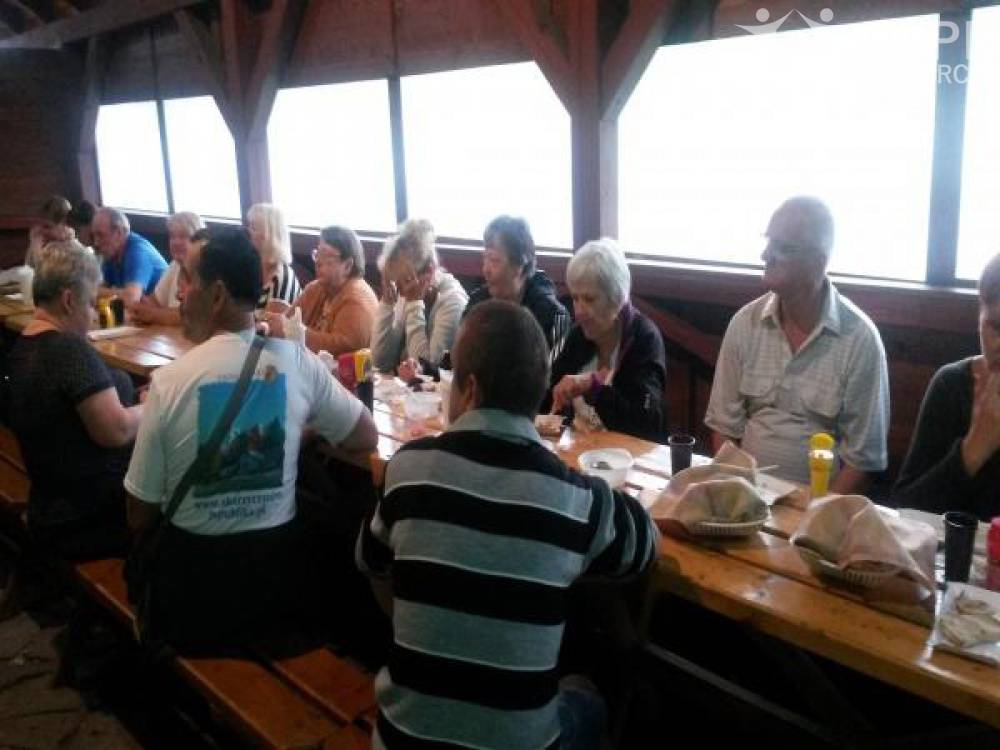 Zdjęcie: Uczestniczki i uczestnicy siedzą przy stole podczas kolacji grillowej